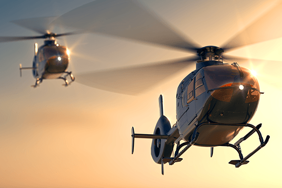 Helicopters against a sunset sky.